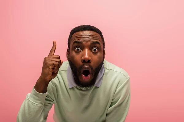 Hombre afroamericano asombrado teniendo idea aislado en rosa - foto de stock