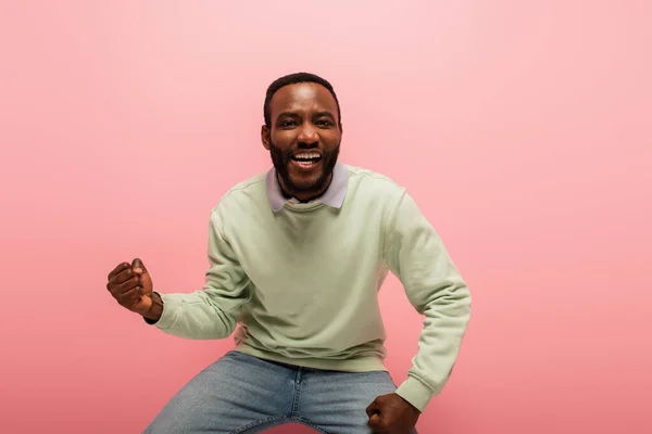 Souriant homme afro-américain montrant un geste oui isolé sur rose — Photo de stock