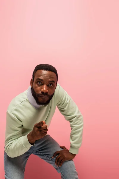 Joven afroamericano hombre apuntando a la cámara aislado en rosa - foto de stock