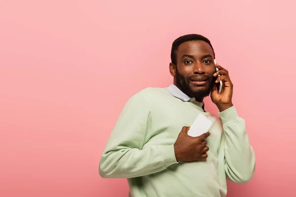Verängstigter Afroamerikaner spricht auf Smartphone isoliert auf rosa — Stockfoto