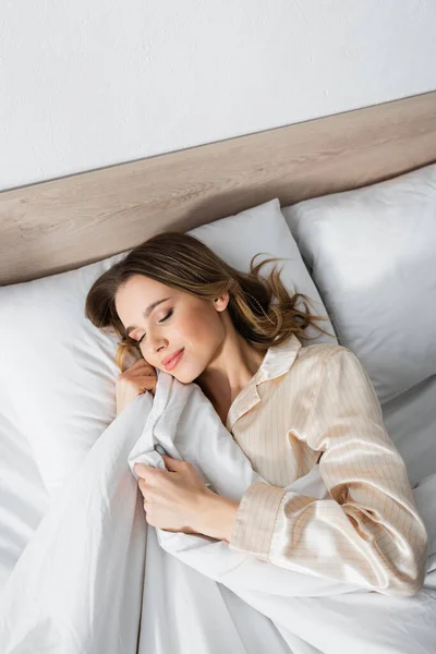 Vista dall'alto della giovane donna che dorme sul letto — Foto stock