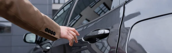 Teilansicht des Geschäftsmannes im beigen Anzug, der die Autotür erreicht, Banner — Stockfoto