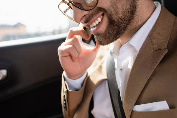 Cropped view of happy man talking on smartphone in car — Stock Photo