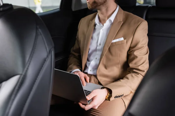 Partial view of businessman in suit working remotely in car — Stock Photo