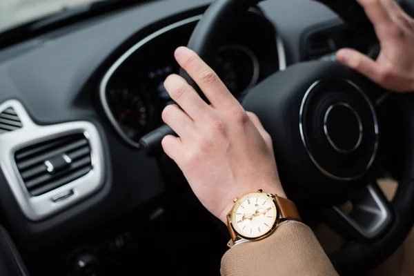 Vista ritagliata dell'uomo con orologio da polso guida auto — Foto stock