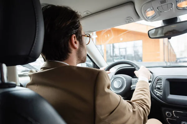 Вид ззаду чоловіка в піджаку водіння автомобіля — стокове фото