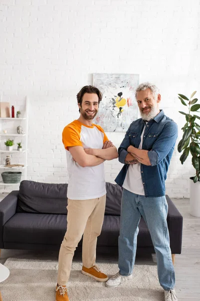 Reif vater und sohn looking bei camera im wohnzimmer — Stockfoto