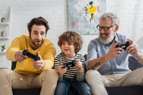 KYIV, UCRANIA - 12 DE ABRIL DE 2021: Padres positivos jugando videojuegos con niños - foto de stock