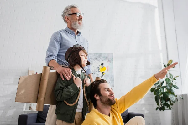 Щасливі батьки грають з хлопчиком в авіаційному костюмі — Stock Photo