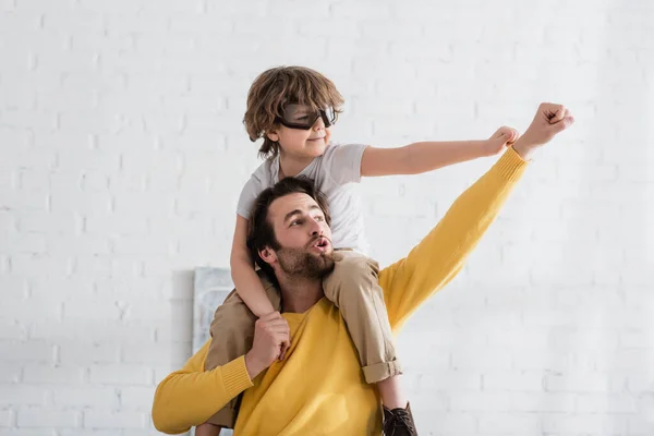 Father and son in aviator goggles showing yes gesture — Stock Photo