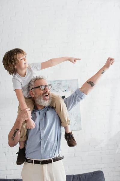 Excited boy and grandfather gesturing at home — Stock Photo