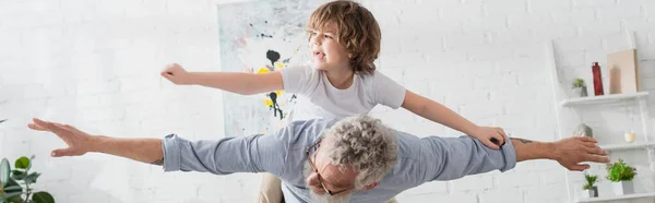 Nonno che gioca con il bambino in salotto, striscione — Foto stock