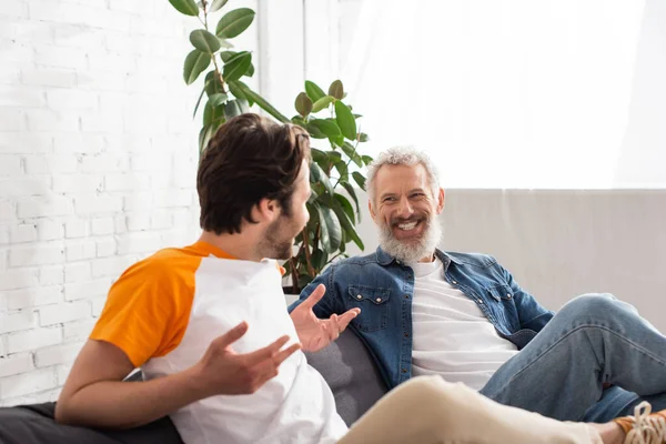 Mature man smiling at blurred son at home — Stock Photo