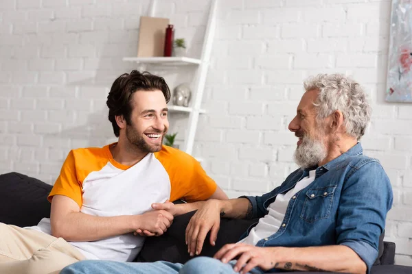 Cheerful man looking at mature father — Stock Photo