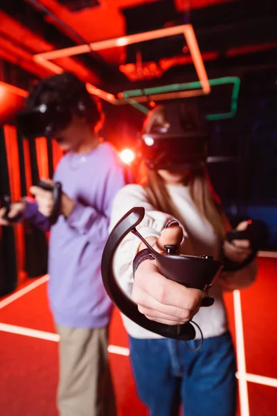 Размытые подростки в виртуальных наушниках игры в игровой зоне — стоковое фото