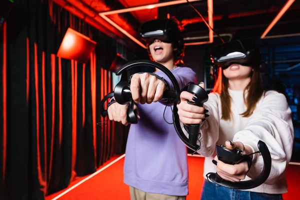 Thrilled teenage gamers in vr headsets having fun in play zone — Stock Photo