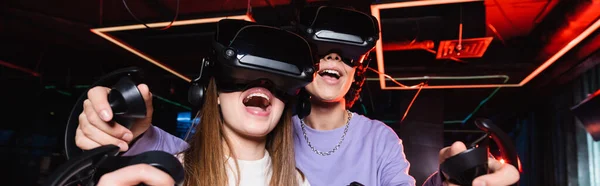 Excited teenagers gaming in vr headsets, banner — Stock Photo