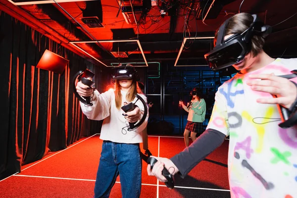 Multiethnic friends in vr headsets gaming in play zone — Stock Photo