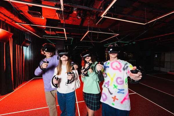 Изумленные мультиэтнические подростки, играющие в виртуальных наушниках — стоковое фото