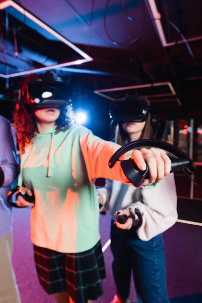 Afrikanisch-amerikanische Mädchen in vr Headset-Gaming in der Nähe verschwommene Freunde — Stockfoto