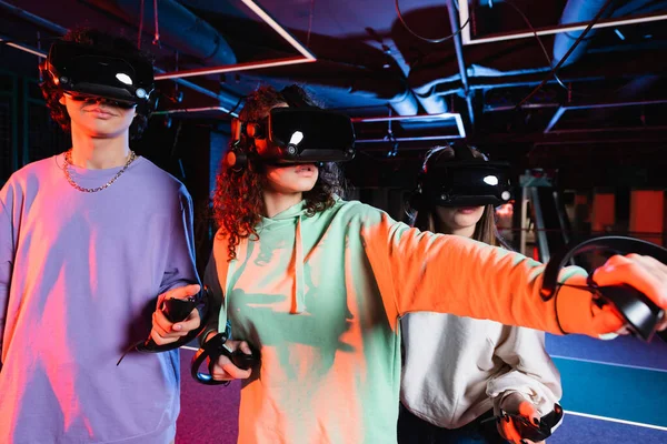 Interracial teenage friends in vr headsets gaming in play zone — Stock Photo