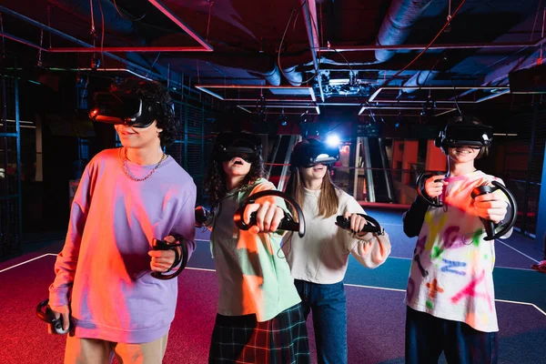Amazed multicultural friends gaming in vr headsets in play zone — Stock Photo