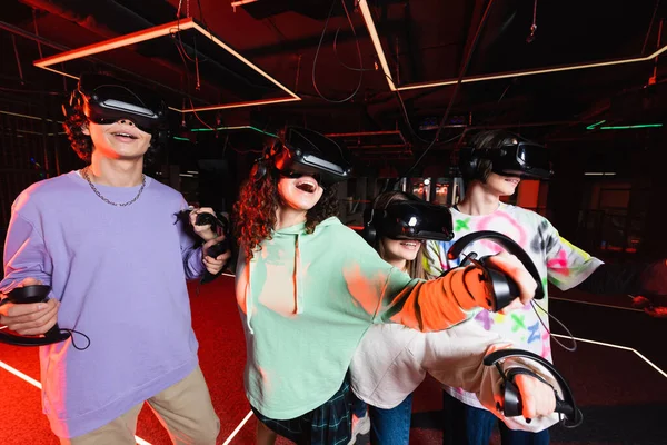 Amigos multiétnicos surpresos se divertindo na zona de jogo vr — Fotografia de Stock