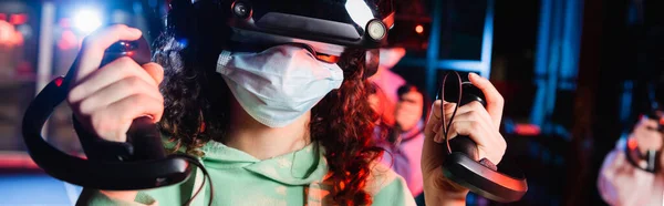 Cropped view of african american girl in medical mask gaming in vr play zone, banner — Stock Photo