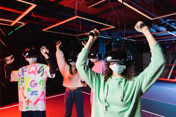 Interracial gamers in medical masks and vr headsets showing win gesture — Stock Photo