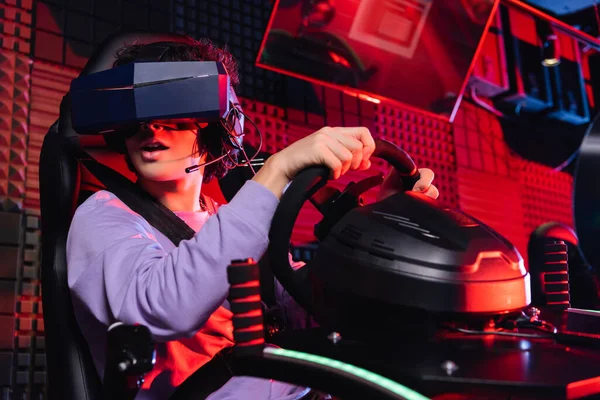 Amazed teenager gaming on car racing simulator in vr headset — Stock Photo