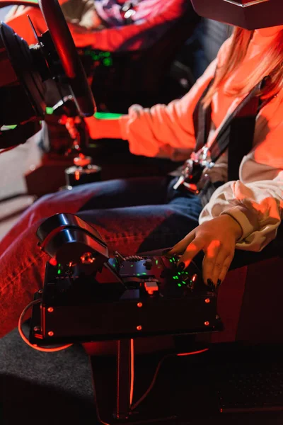 Vue recadrée de la boîte de vitesse de fonctionnement adolescent tout en jouant dans le simulateur de course automobile — Photo de stock