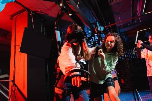 Excited african american girl near friend gaming in vr headset — Stock Photo