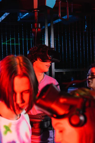 Verschwommene Freunde spielen in vr-Zone im Neonlicht — Stockfoto