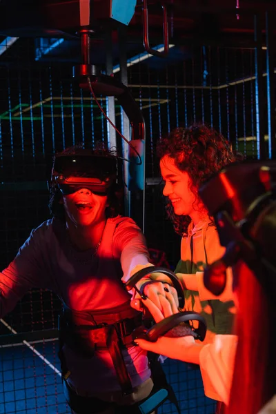 Excited guy gaming in vr headset near smiling african american friend — Stock Photo