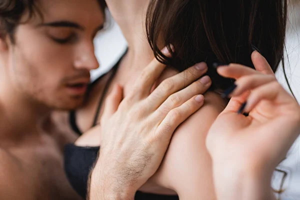 Blurred man touching sensual girlfriend in bra — Stock Photo