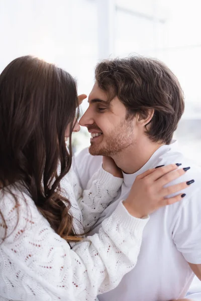 Uomo sorridente guardando la ragazza in maglione a casa — Foto stock