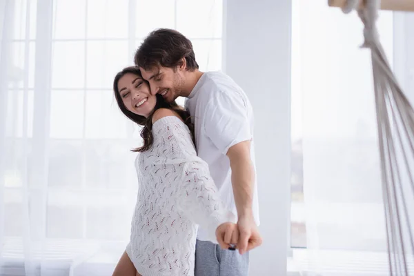 Alegre pareja cogida de la mano en casa - foto de stock