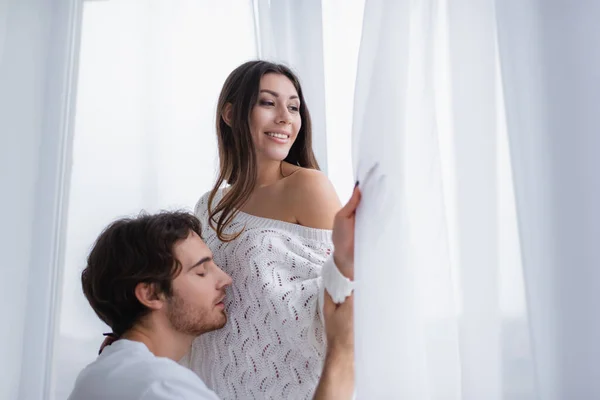 Улыбающаяся женщина смотрит в окно рядом с парнем — стоковое фото