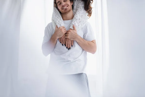 Woman embracing boyfriend near curtain at home — Stock Photo