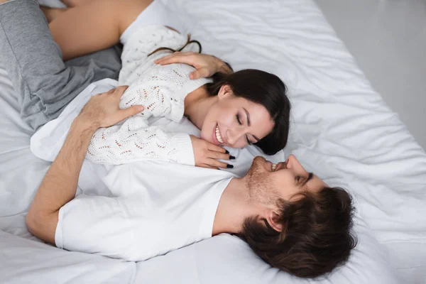 Sorrindo mulher deitada no peito do namorado no quarto — Fotografia de Stock