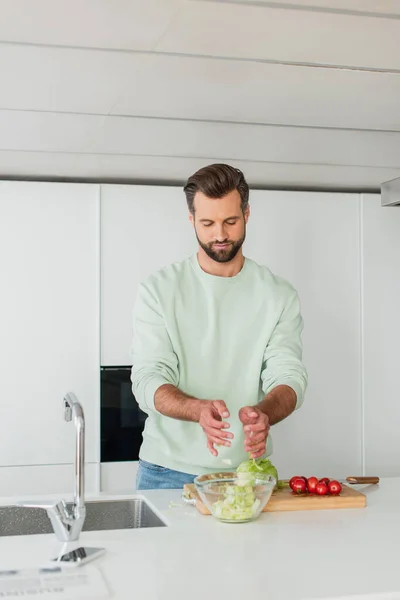 Homme préparant la salade de légumes frais pour le petit déjeuner — Photo de stock