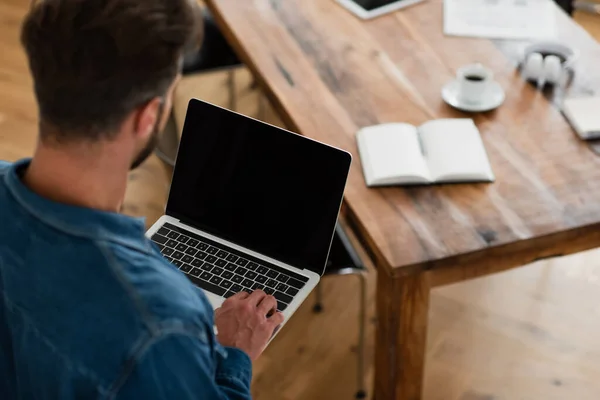 Freelancer borrado digitando no laptop com tela em branco em casa — Fotografia de Stock