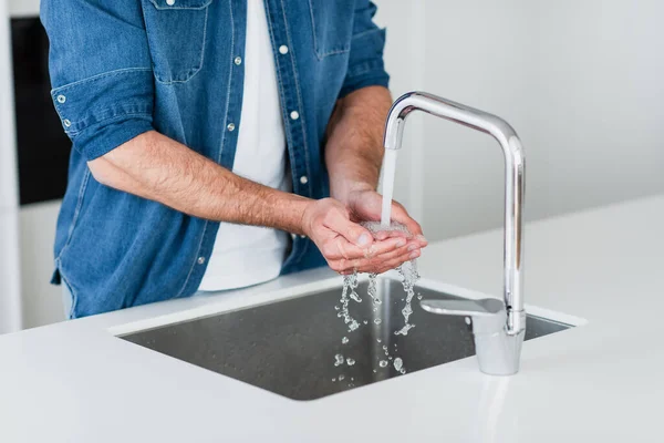 Teilbild eines Mannes im Jeanshemd, der sich zu Hause die Hände wäscht — Stock Photo
