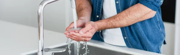 Частковий вид на дорослого чоловіка, що миє руки вдома, банер — стокове фото