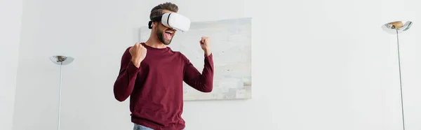 Aufgeregter Mann zeigt Yah-Geste beim Spielen in vr Headset zu Hause, Banner — Stockfoto