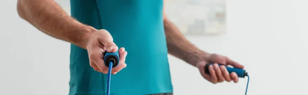 Cropped view of sportsman with jump rope, banner — Stock Photo