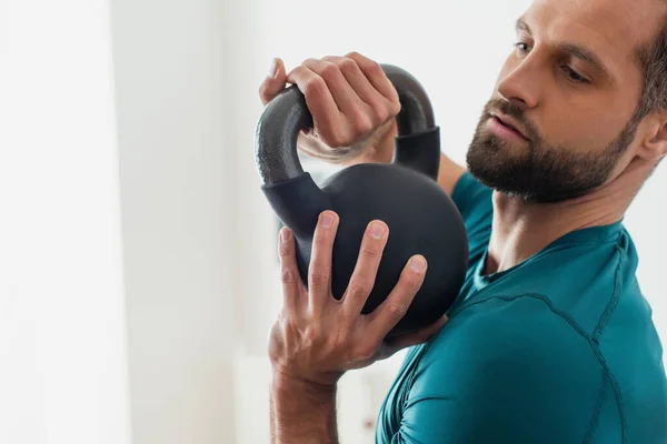 Adult athletic man training with kettlebell at home — Stock Photo