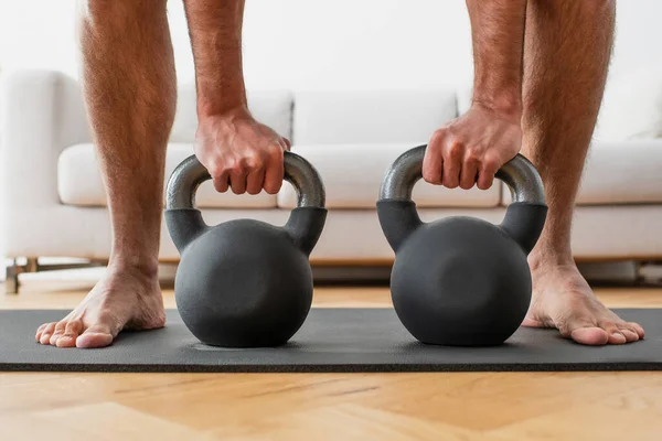 Vista parcial del hombre descalzo levantando pesas en la colchoneta de fitness - foto de stock