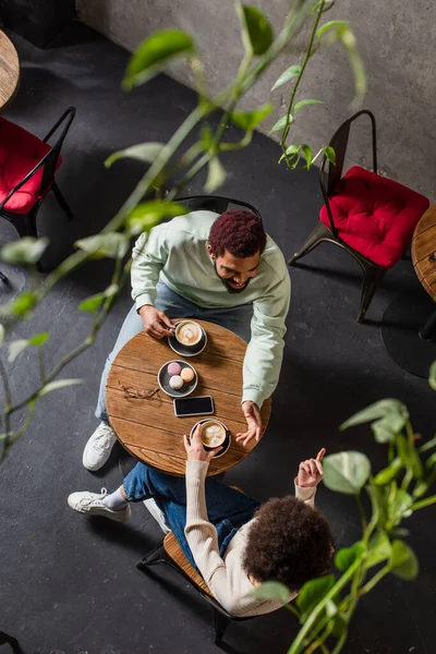 Vue aérienne du couple afro-américain avec café parlant dans un café — Photo de stock