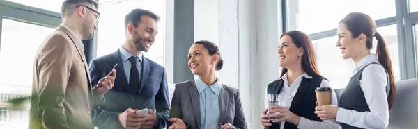 Alegre mujer de negocios afroamericana hablando con colegas con bebidas, pancarta - foto de stock